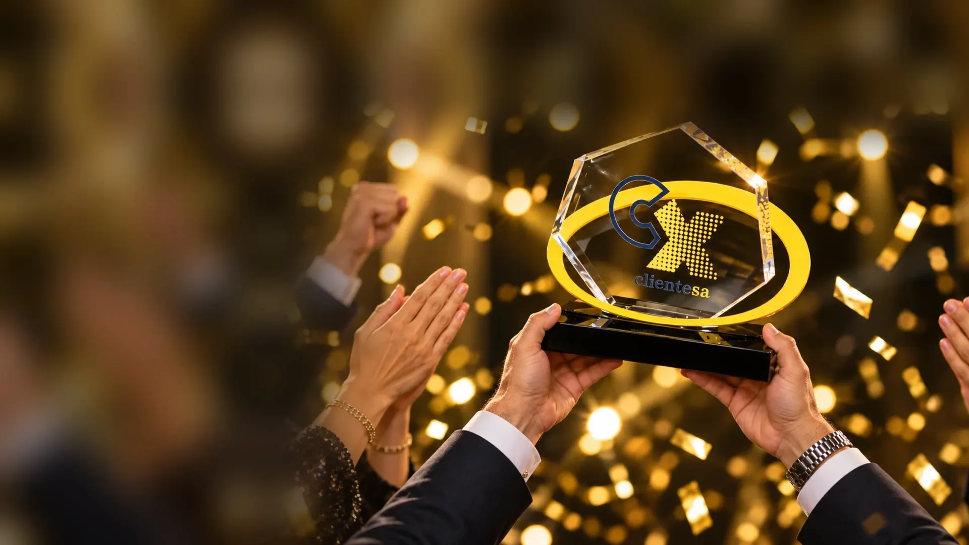 Troféu do Prêmio CX ClienteSA erguido sob aplausos e confete dourado